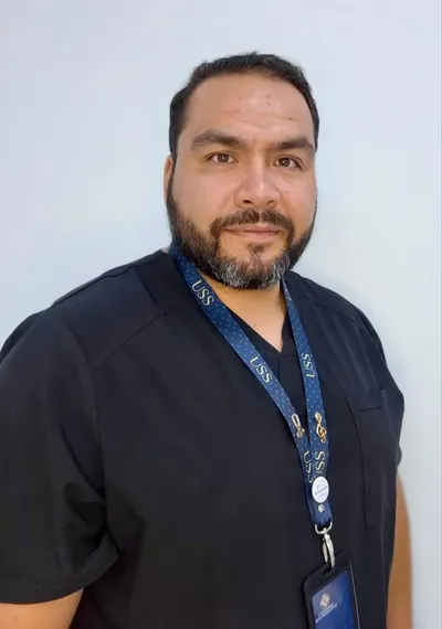 Juan Manuel Parada con uniforme clínico negro y credencial de la Universidad San Sebastián.